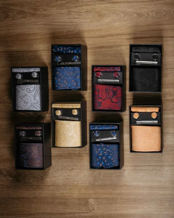 Verschiedene Accessoire-Sets in Geschenkboxen auf Holz